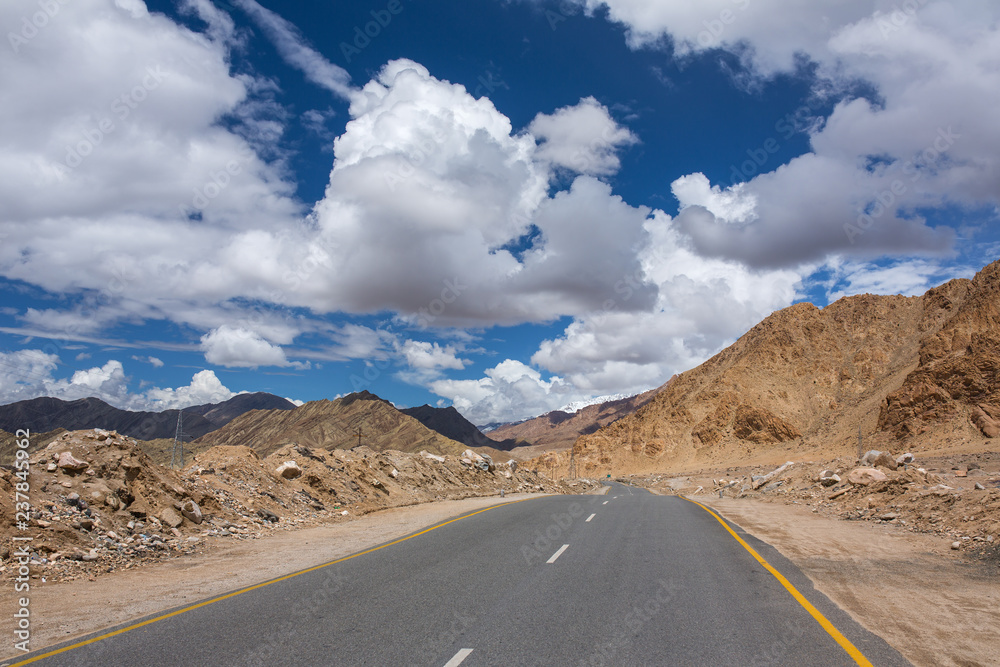 Empty road through HImalayas mountains in Ladakh, Northern India. Road trip concept