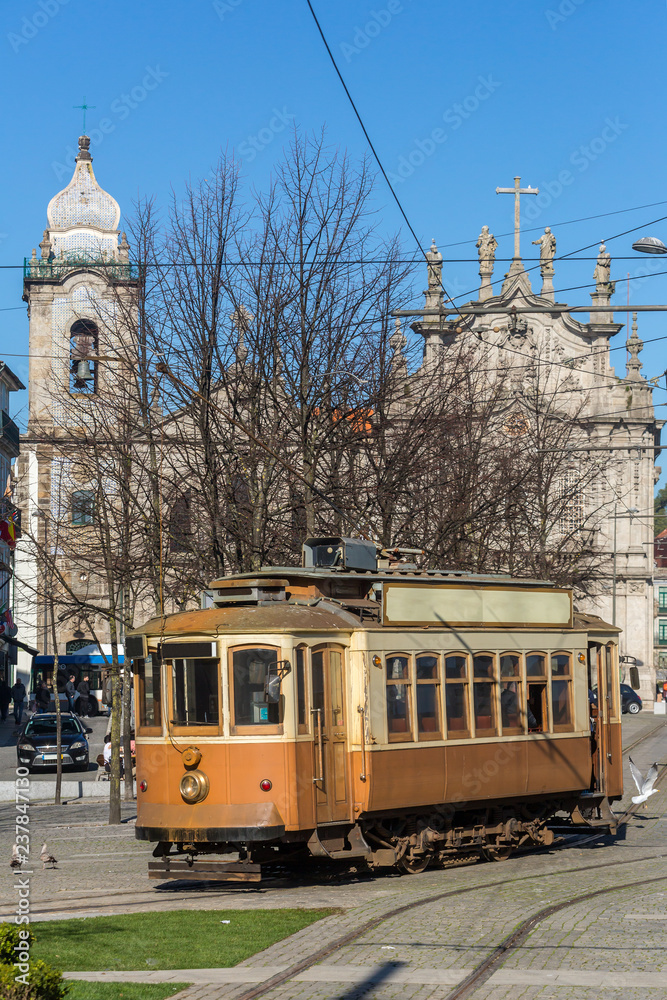 Old tram with famous church Igreja do Carmo dos Carmelitas in Ribeirain Porto, Portugal.