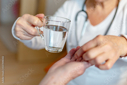 Pflegekraft gibt Rentnerin eine Tablette