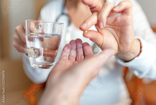Pflegekraft gibt Rentnerin  eine Tablette