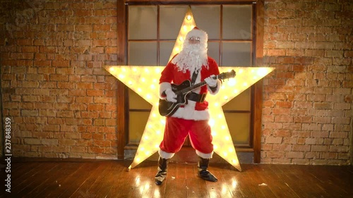 Santa Claus rock star, plays christmas songs by guitar, have fun, celebrate holidays