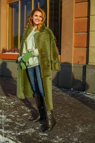 Cheerful winter woman in green coat outdoors