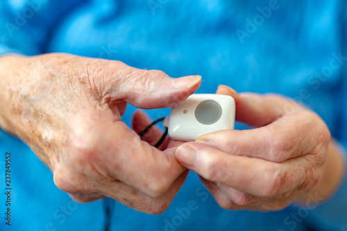 Rentnerin h  lt einen Notfallknopf in der Hand