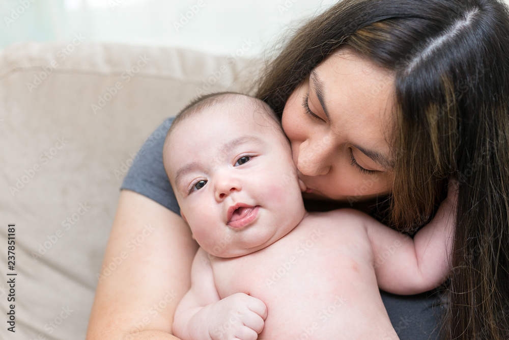 mother is kissing her cute infant son mother is kissing her cute infant son