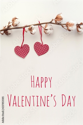 Cotton branch and two red paper hearts with text Valentine's Day