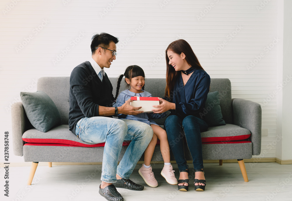 Asian daughter holding present with father and mother. concept surprise gift box for Birthday Day. Asian daughter holding present with father and mother. concept surprise gift box for Birthday Day.