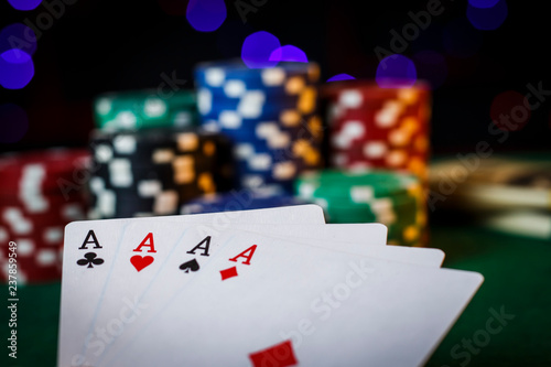 Four aces on the poker table with chips