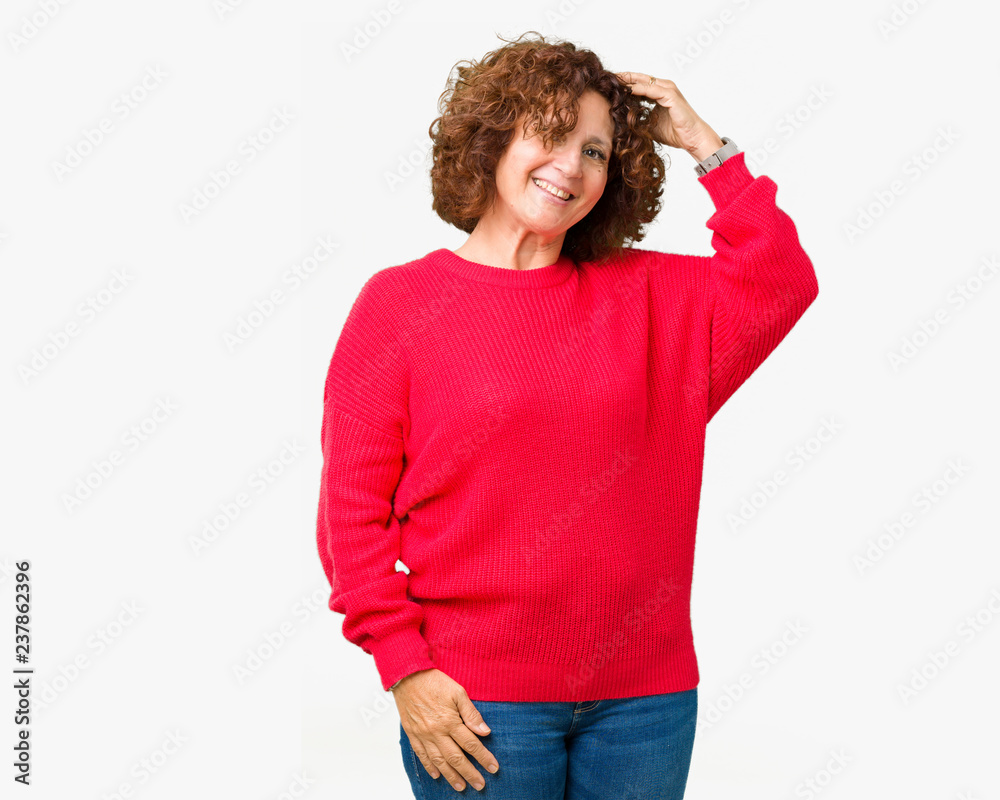Beautiful middle ager senior woman red winter sweater over isolated background Smiling confident touching hair with hand up gesture, posing attractive Beautiful middle ager senior woman red winter sweater over isolated background Smiling confident touching hair with hand up gesture, posing attractive