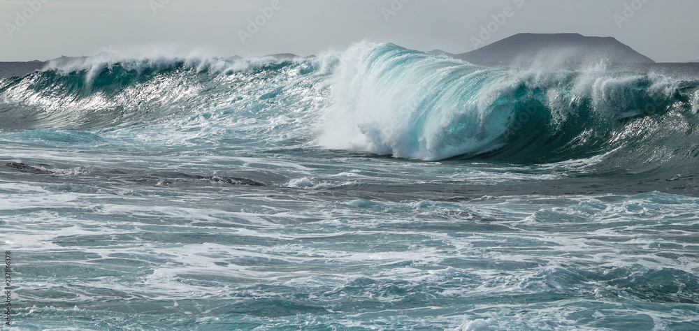 Turquoise tunnel wave strike against shallow water. Atlantic ocean.
