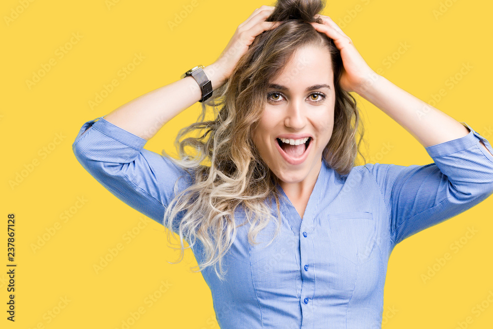 Fototapeta premium Beautiful young blonde business woman over isolated background Crazy and scared with hands on head, afraid and surprised of shock with open mouth