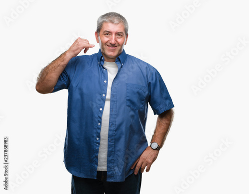 Handsome senior man over isolated background smiling doing phone gesture with hand and fingers like talking on the telephone. Communicating concepts.