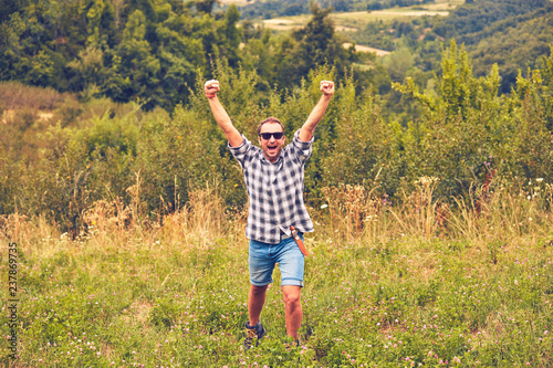 Man hiker with arms wide open in the field.