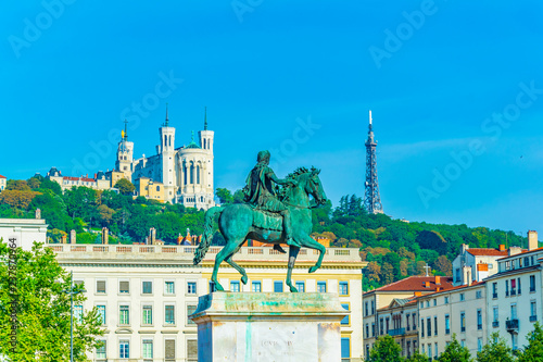 Basilica Notre-Dame de Fourviere viewed behind statue of Louis XIV in Lyon, France photo