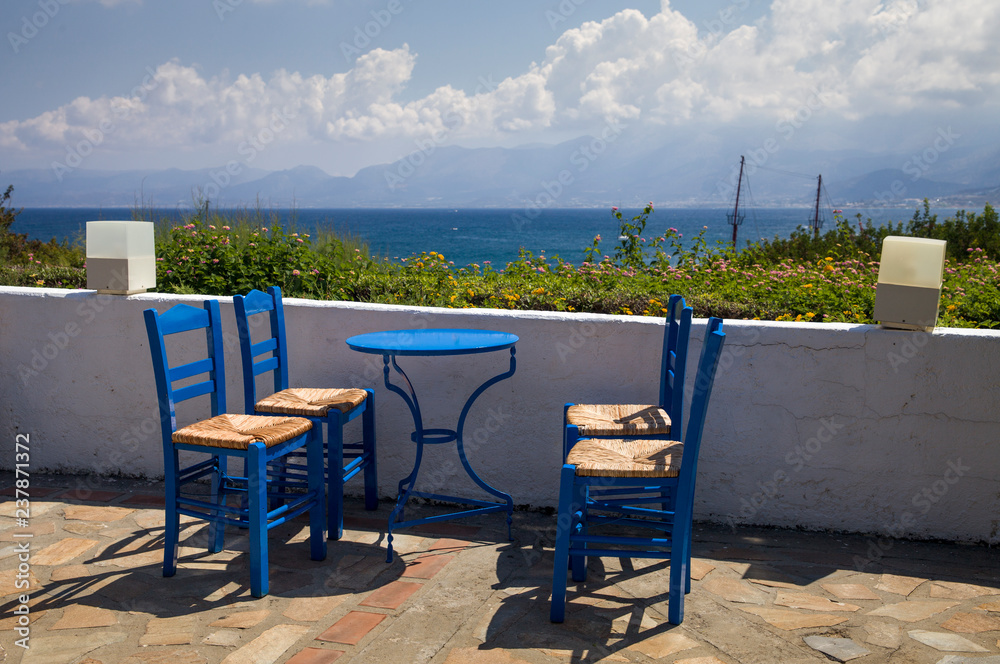 Blue chairs and tables in the restaurant. A place to eat on the seashore.