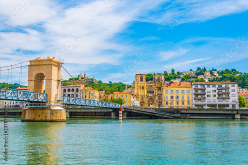 Cathedral in Vienne viewed behind a pedestrian bridge over river Rhone, France photo