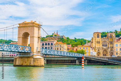 Cathedral in Vienne viewed behind a pedestrian bridge over river Rhone, France photo