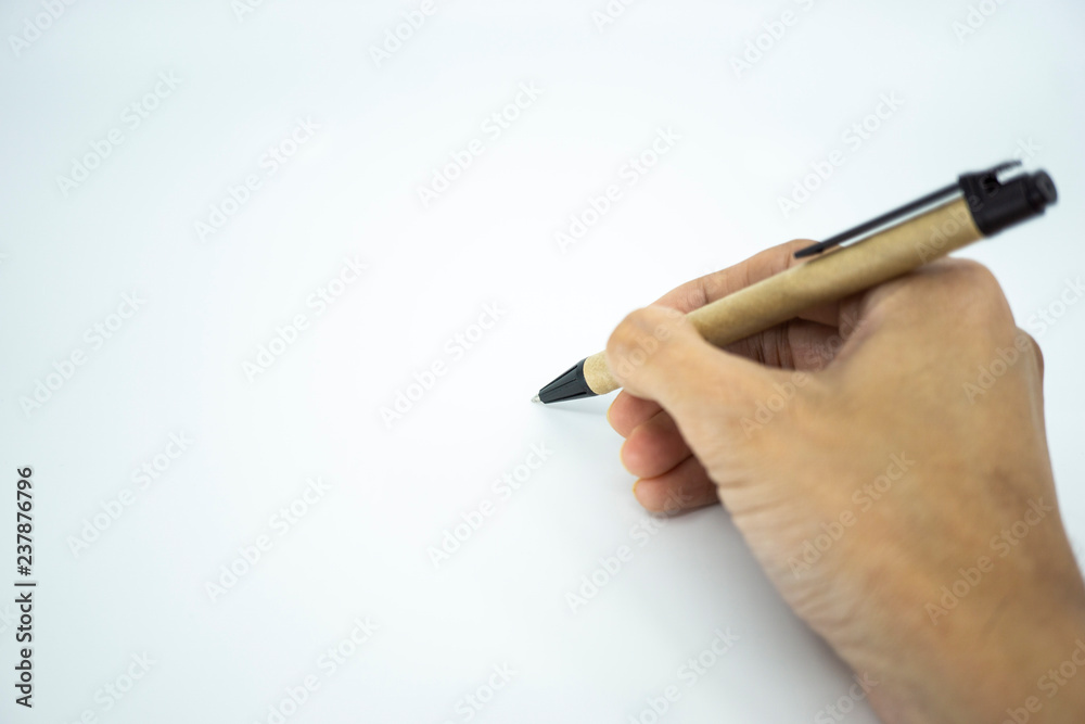 Hand holding ballpoint pen pointing on white paper. Selective focus.