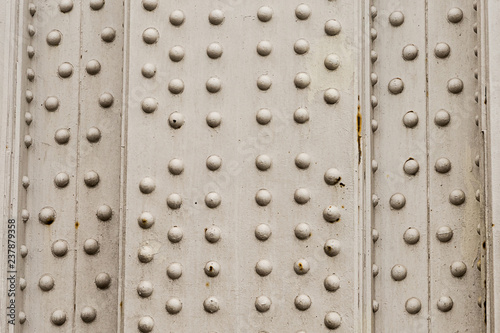 metal background with many rivets vertical panel weathering corrosion industrial design base silver