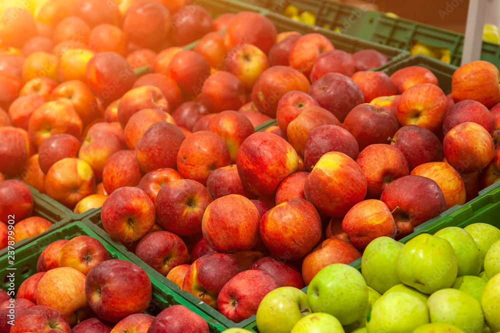 Beautiful, ripe, fresh fruits in the store: green, yellow, red apples, laid out in rows on the shelves, attracting the attention of buyers and offering a large assortment. Paradise for a vegetarian. Beautiful, ripe, fresh fruits in the store: green, yellow, red apples, laid out in rows on the shelves, attracting the attention of buyers and offering a large assortment. Paradise for a vegetarian.