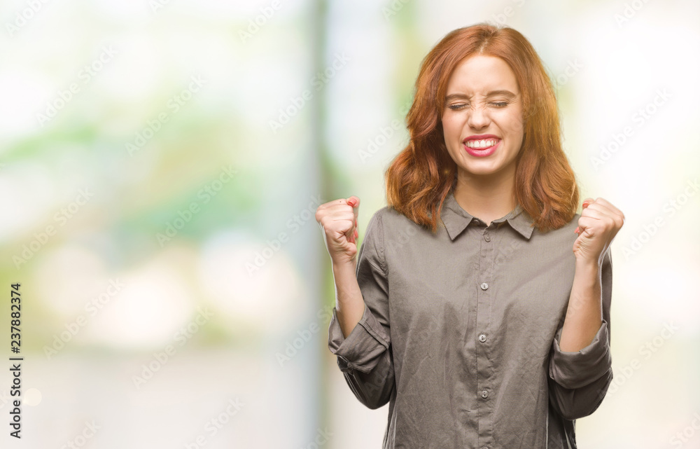 Young beautiful woman over isolated background excited for success with arms raised celebrating victory smiling. Winner concept. Young beautiful woman over isolated background excited for success with arms raised celebrating victory smiling. Winner concept.