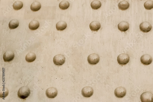 abstract background industrial metal base beige surface rivets row uneven surface