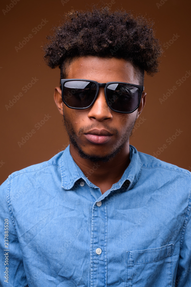 Obraz premium Portrait of young handsome African man wearing sunglasses