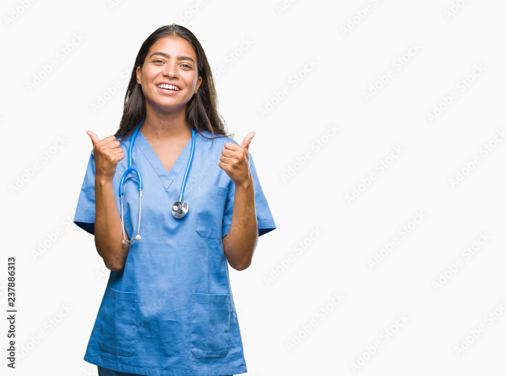 Young arab doctor surgeon woman over isolated background success sign doing positive gesture with hand, thumbs up smiling and happy. Looking at the camera with cheerful expression, winner gesture. Young arab doctor surgeon woman over isolated background success sign doing positive gesture with hand, thumbs up smiling and happy. Looking at the camera with cheerful expression, winner gesture.
