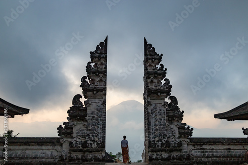 Man is standing in the gate of Pura Lempuyang temple. Mount Agung on the background. Bali island, Indonesia