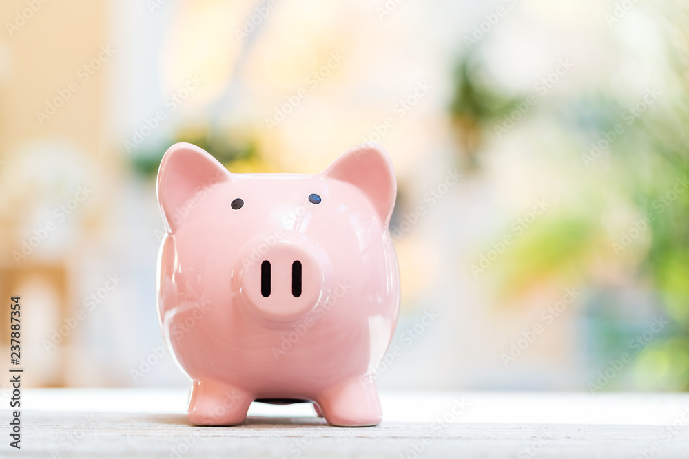 Piggy bank on a bright interior room background Piggy bank on a bright interior room background