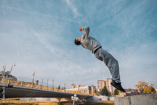 Sporty man perfrom high backflip jumping in the park photo