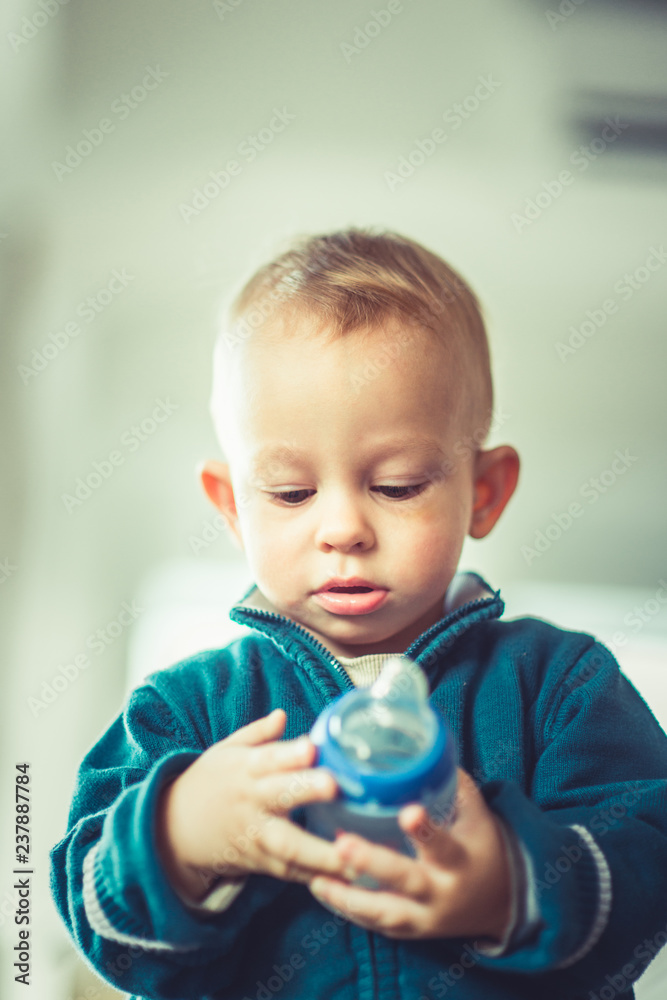 Nice baby wearing blue holding a bottle Nice baby wearing blue holding a bottle