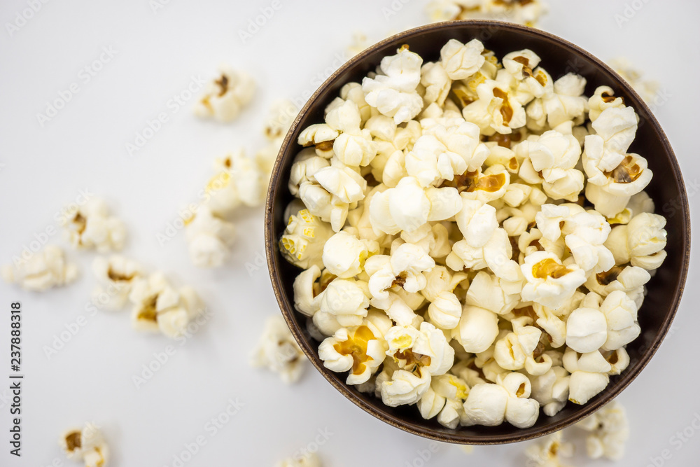 Popcorn in wooden bowl isolated on white background. Top view.Selective focus.