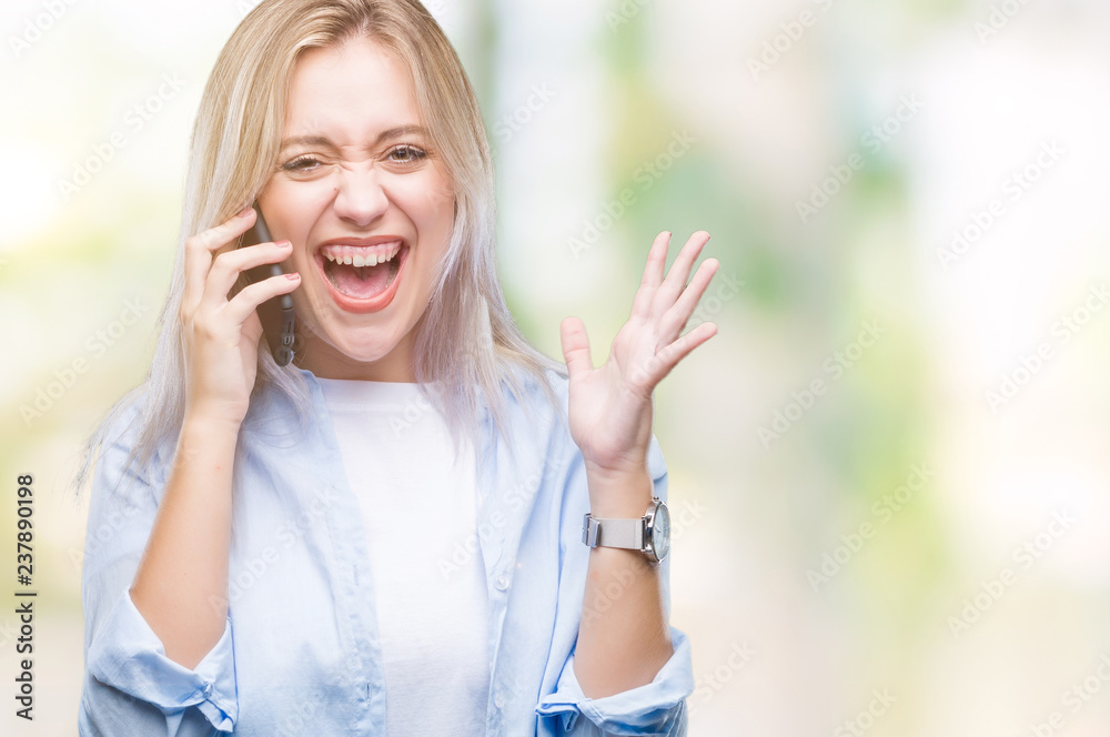 Young blonde woman talking using smarpthone over isolated background very happy and excited, winner expression celebrating victory screaming with big smile and raised hands