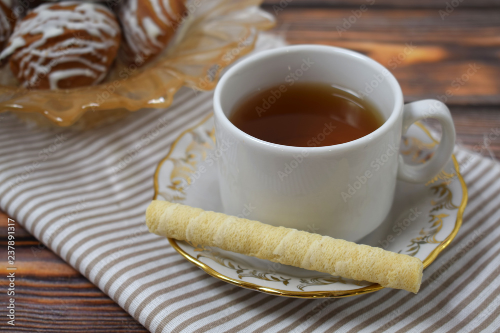 A Cup of fragrant tea and delicious sweet cookies on a wooden background. A Cup of fragrant tea and delicious sweet cookies on a wooden background.