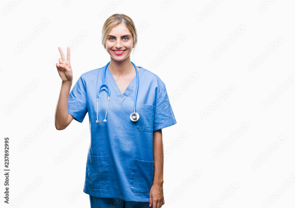 Young beautiful blonde doctor surgeon nurse woman over isolated background showing and pointing up with fingers number two while smiling confident and happy. Young beautiful blonde doctor surgeon nurse woman over isolated background showing and pointing up with fingers number two while smiling confident and happy.