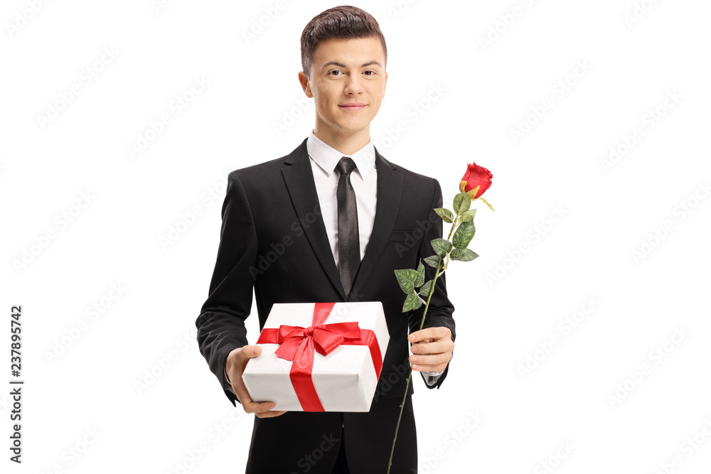 Elegantly dressed handsome teenage boy holding a present and a rose Elegantly dressed handsome teenage boy holding a present and a rose