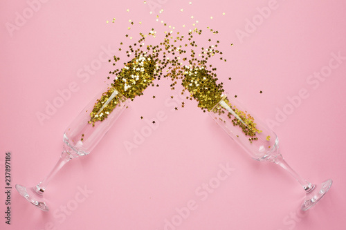 Valokuva Champagne glasses with golden stars confetti on pink color paper background mini