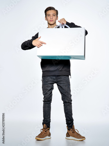 Teen boy is pointing by finger to empty white paper