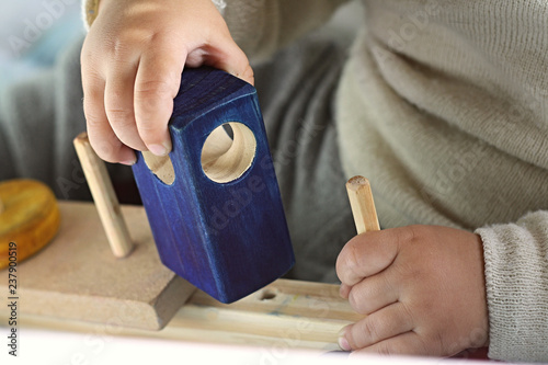 Criança brincando de encaixar brinquedo didático de madeira photo