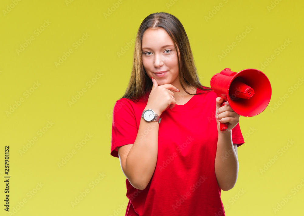 Young caucasian woman yelling through megaphone over isolated background serious face thinking about question, very confused idea Young caucasian woman yelling through megaphone over isolated background serious face thinking about question, very confused idea