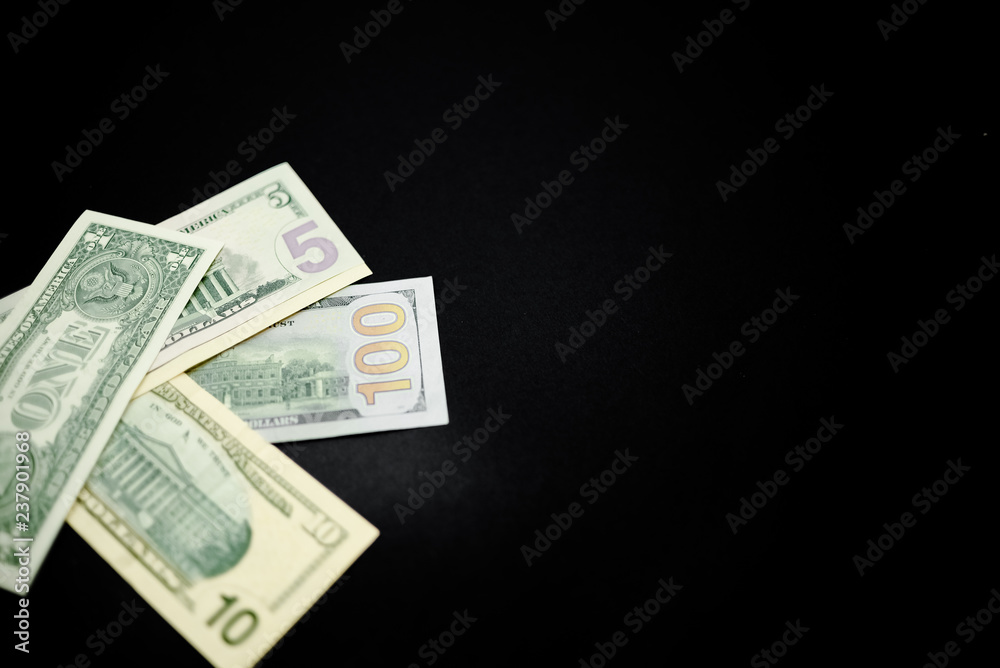 Dollars on dark black abstract background. Horizontal top view, several objects. One hundred dollars Dollars on dark black abstract background. Horizontal top view, several objects. One hundred dollars