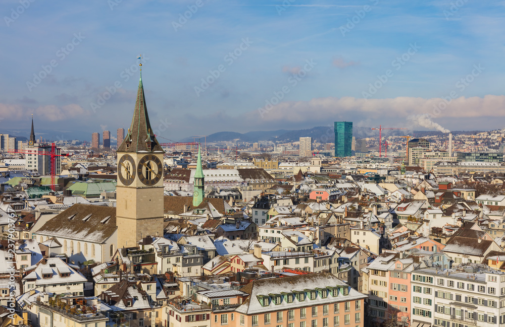 The city of Zurich in Switzerland as seen from the tower of the Grossmunster cathedral in winter, tower of the St. Peter Church in the foreground. Zurich is the largest city in Switzerland.