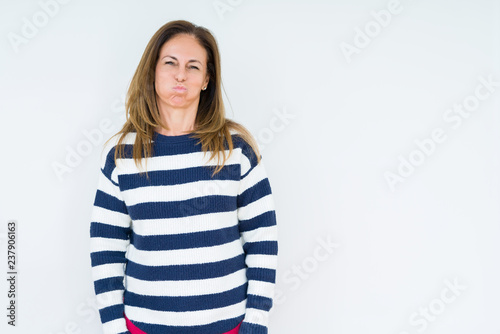 Beautiful middle age woman wearing navy sweater over isolated background puffing cheeks with funny face. Mouth inflated with air, crazy expression.