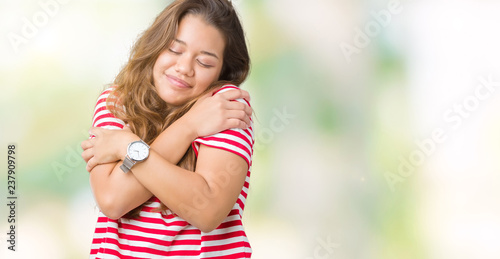 Young beautiful brunette woman wearing stripes t-shirt over isolated background Hugging oneself happy and positive, smiling confident. Self love and self care