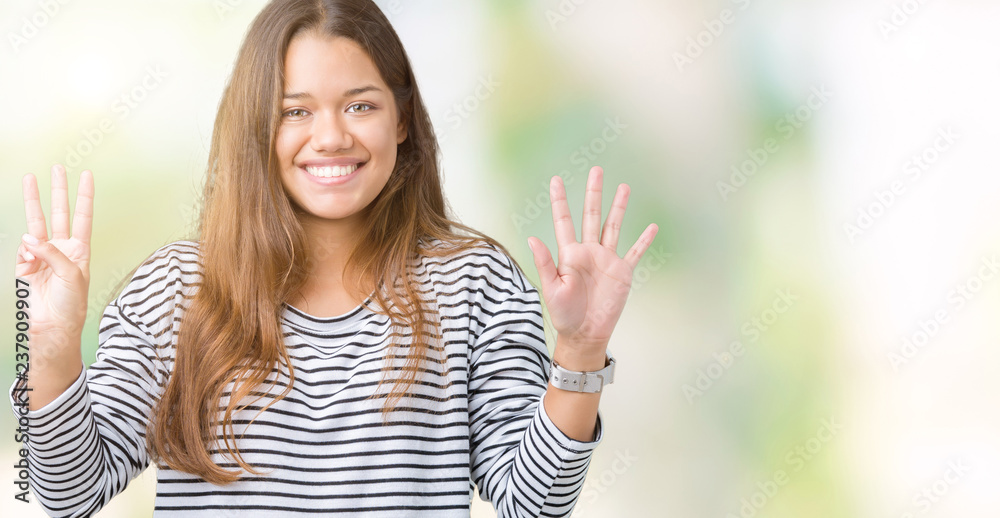 Young beautiful brunette woman wearing stripes sweater over isolated background showing and pointing up with fingers number eight while smiling confident and happy. Young beautiful brunette woman wearing stripes sweater over isolated background showing and pointing up with fingers number eight while smiling confident and happy.