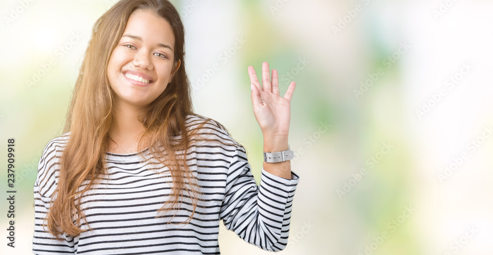 Young beautiful brunette woman wearing stripes sweater over isolated background Waiving saying hello happy and smiling, friendly welcome gesture Young beautiful brunette woman wearing stripes sweater over isolated background Waiving saying hello happy and smiling, friendly welcome gesture