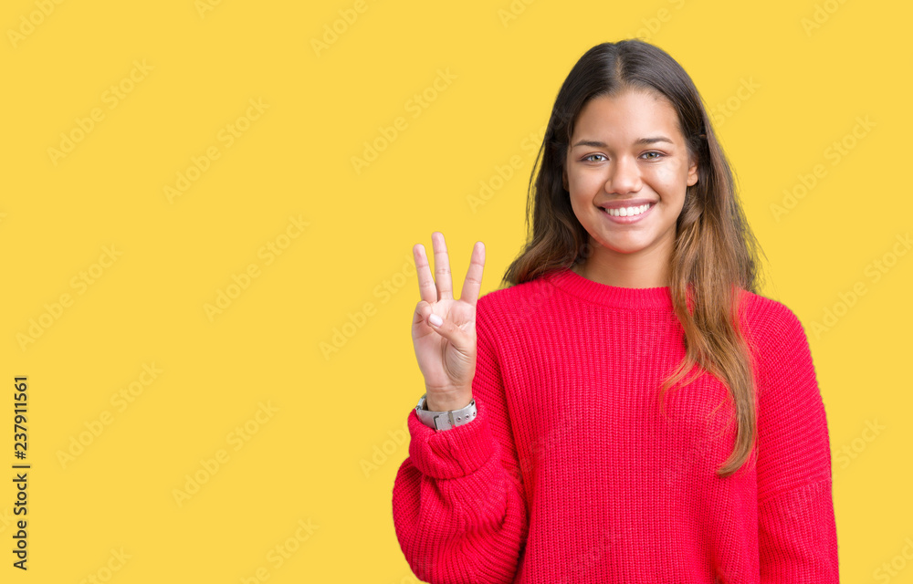 Young beautiful brunette woman wearing red winter sweater over isolated background showing and pointing up with fingers number three while smiling confident and happy. Young beautiful brunette woman wearing red winter sweater over isolated background showing and pointing up with fingers number three while smiling confident and happy.