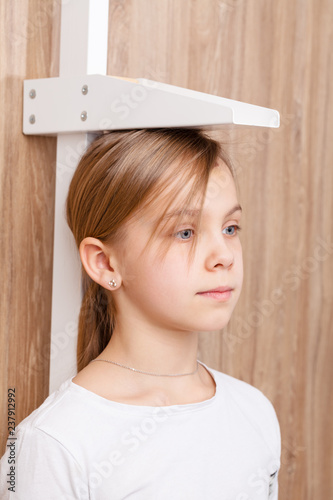 Child check up - measuring stature of preteen girl with stadiometer photo