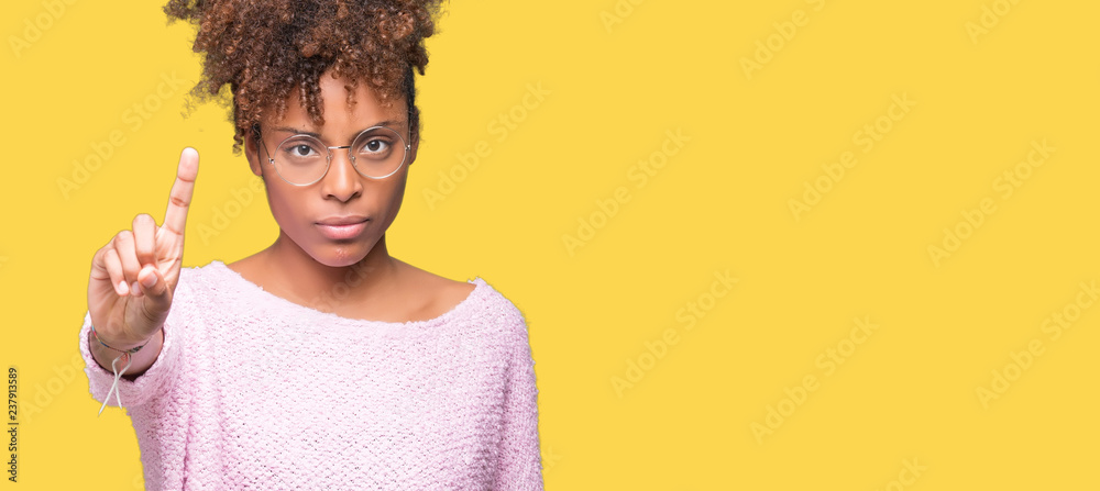 Beautiful young african american woman wearing glasses over isolated background Pointing with finger up and angry expression Beautiful young african american woman wearing glasses over isolated background Pointing with finger up and angry expression
