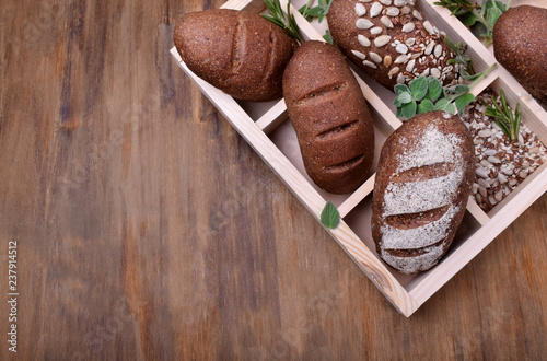 Assortment of little loaves of rye bread in a wooden box. Copy space